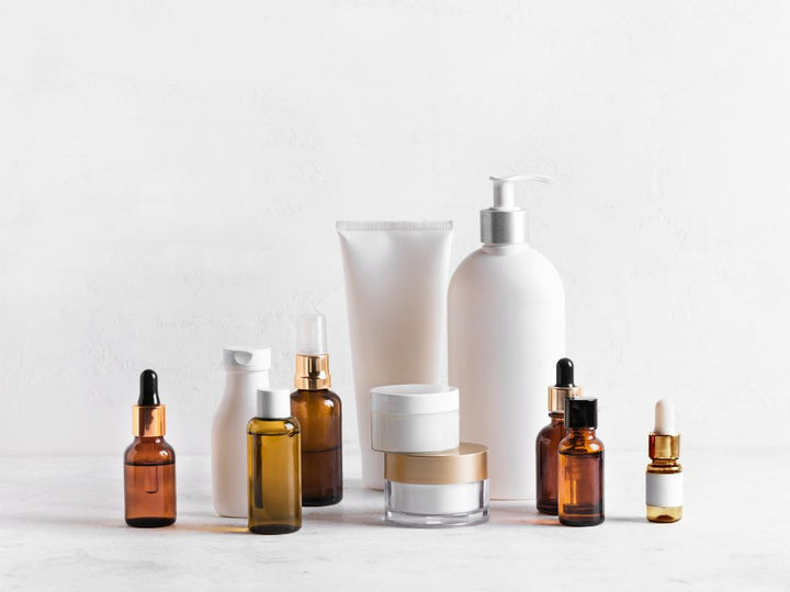 Plain background with a selection of different generic skincare products