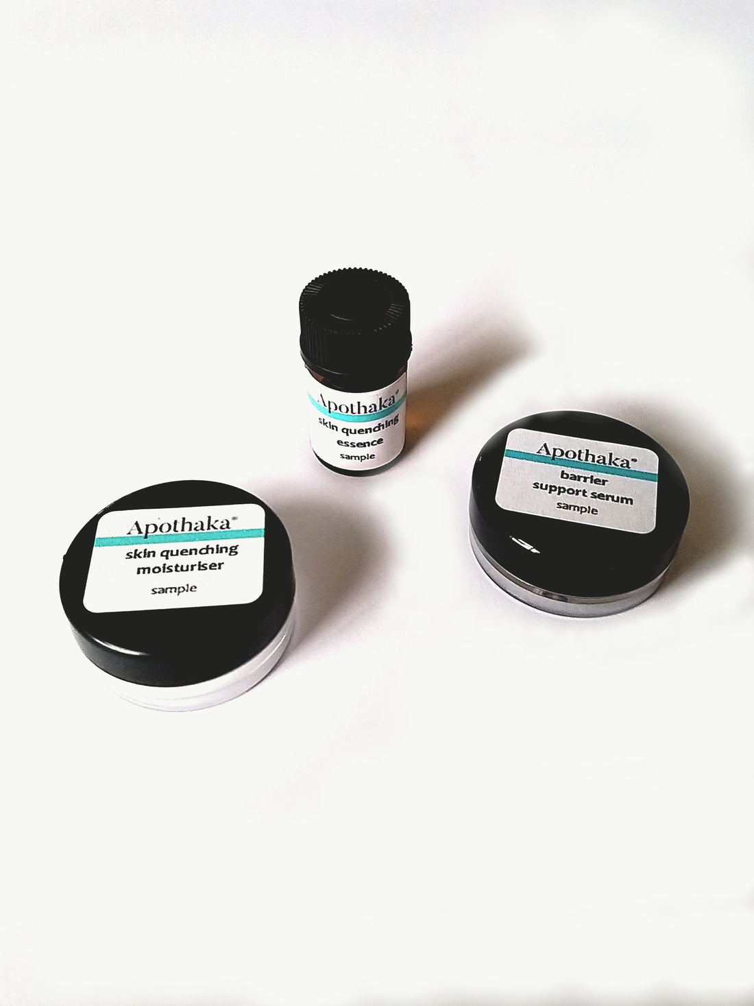 Three small sample jars with black lids, labeled Apothaka, arranged on a white surface.