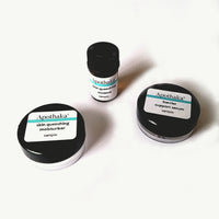Three small sample jars with black lids, labeled Apothaka, arranged on a white surface.